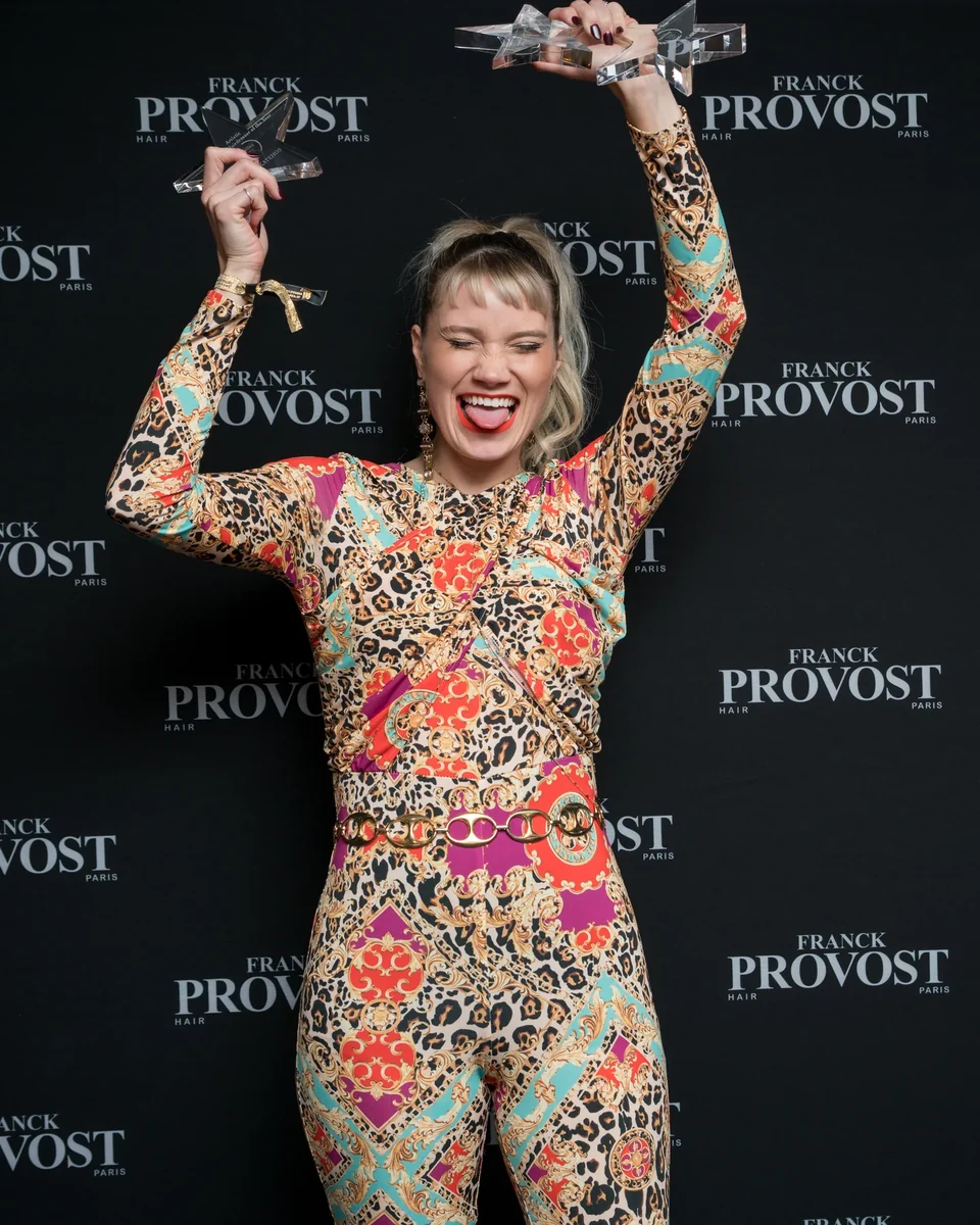 Invitée photographiée dans un mouvement dynamique et joyeux devant le photocall lors d'une soirée d'entreprise